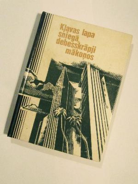 Kļavas lapa sniegā, debesskrāpji makoņos 